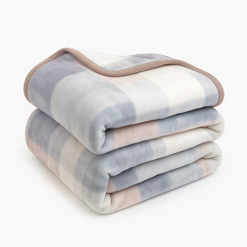 Light-colored Sincdoo PLA blanket, folded neatly, showcasing its soft, breathable fabric ideal for all seasons, providing warmth and comfort without the risk of microplastics.