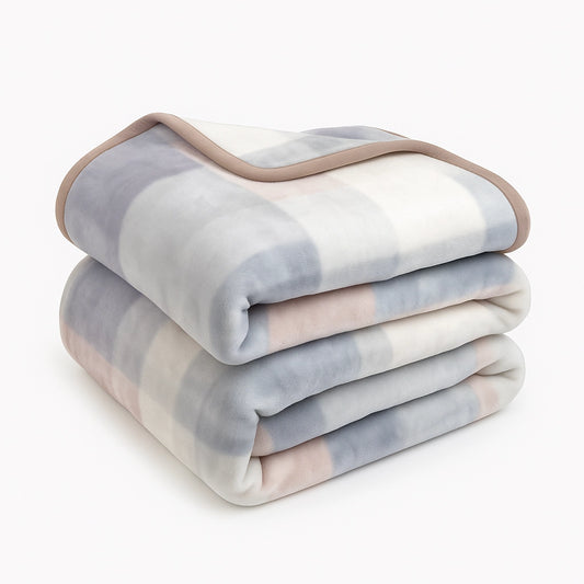 Light-colored Sincdoo PLA blanket, folded neatly, showcasing its soft, breathable fabric ideal for all seasons, providing warmth and comfort without the risk of microplastics.